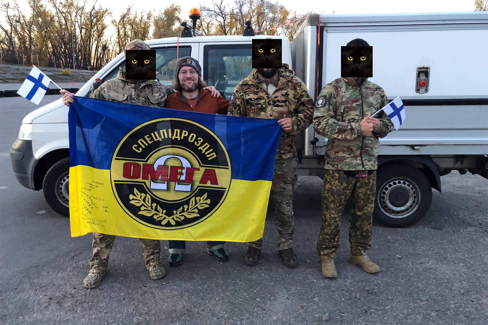 Feeniksin Kilta ry:n puheenjohtaja Markus Mattsson yhdessä erikoisyksikkö Omegan edustajien kanssa. Taustalla Omegalle lahjoitettu ajoneuvo